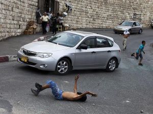 Motorista observa o menino, que fica no chão após ser atropelado.